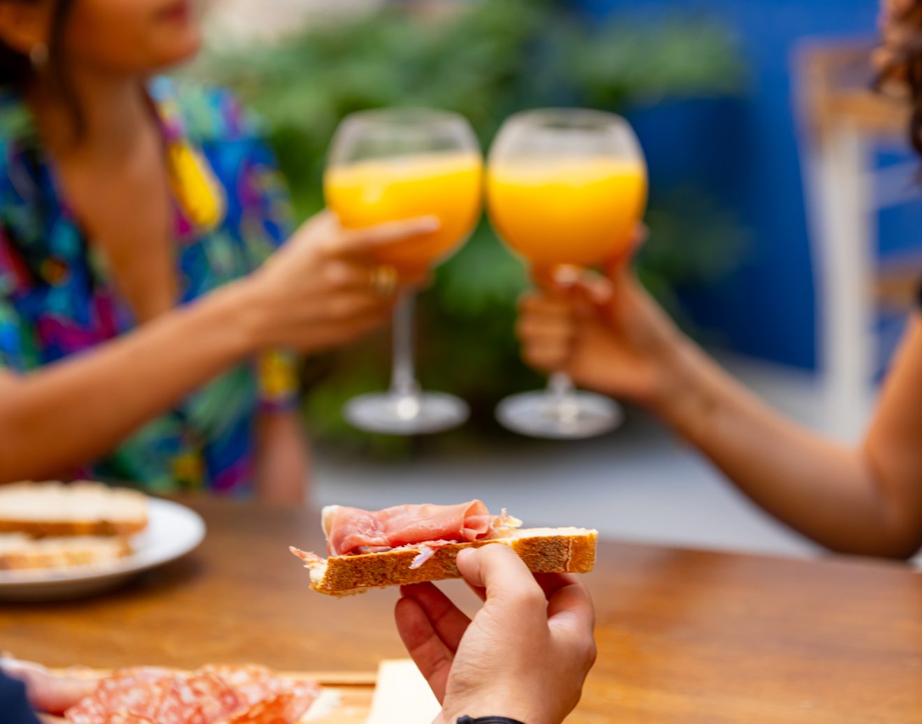 Assortiment de fromage avec personnes qui trinquent en arrière plan