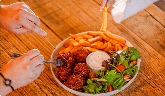 Plat de frites accompagné de boulettes et de salade